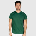 Man wearing a QUAD Ace Padel green T-shirt  with a brand logo on a light grey background