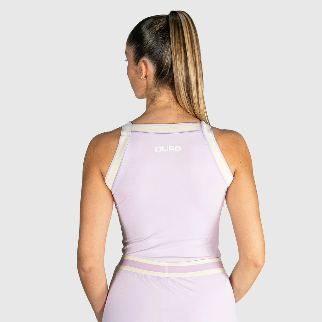 QUAD Aim Padel Top a light purple athletic dress with white straps on a plain background