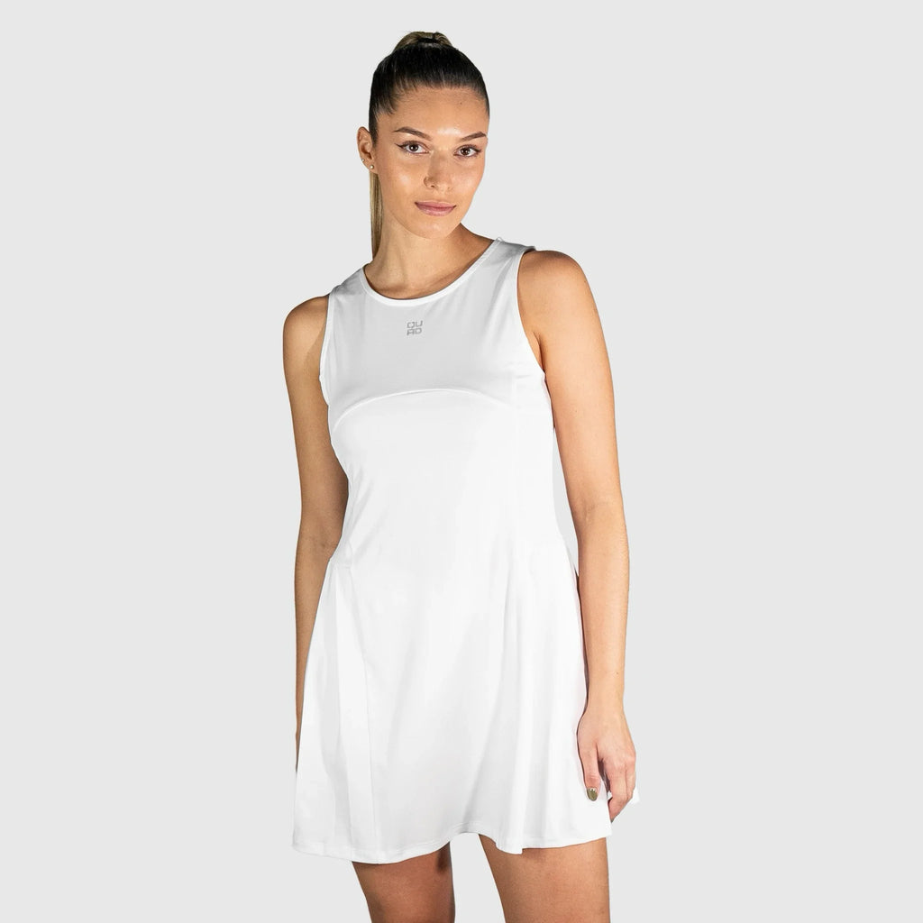 Woman wearing a white QUAD Frame Padel Dress on a light gray background