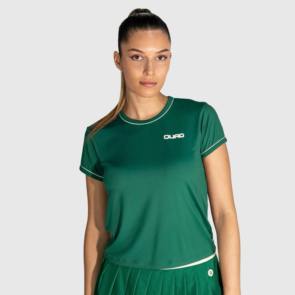 Woman wearing a New Regular Padel shirt  with a visible brand logo on a light gray background