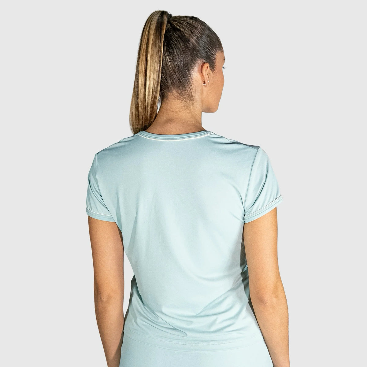 Woman wearing a New Regular Padel shirt  outfit on a plain background