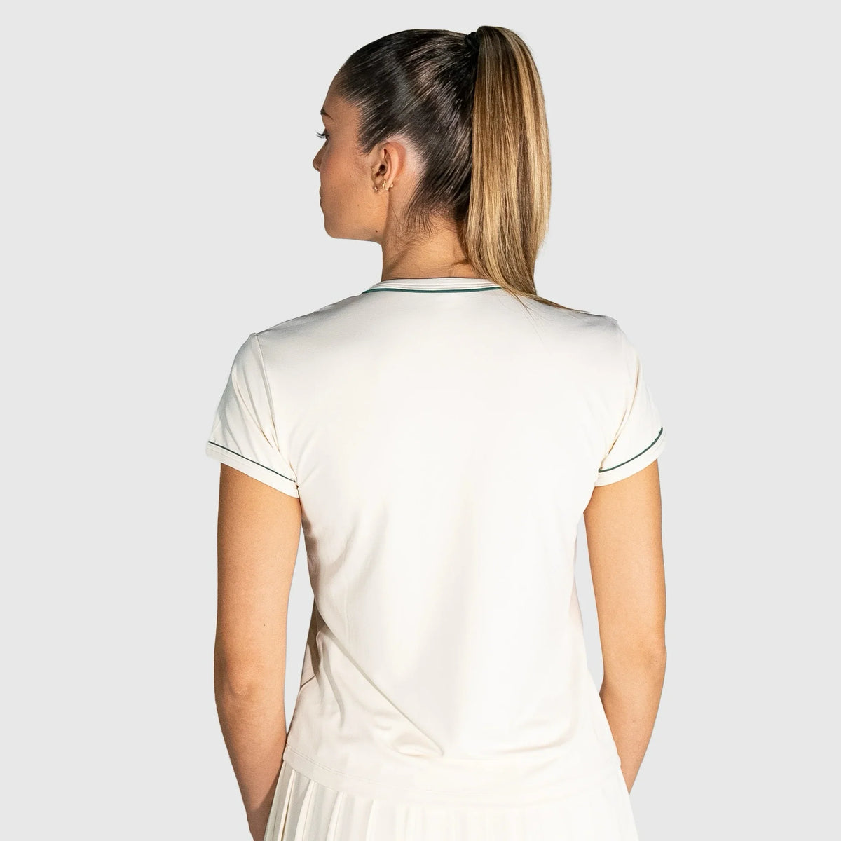 Woman wearing a New Regular Padel shirt with a plain background