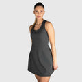 Woman wearing a QUAD Twist Padel Dress against a light grey background