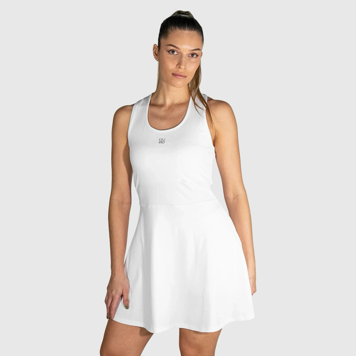 Woman wearing a white  QUAD Twist Padel Dress on a plain background